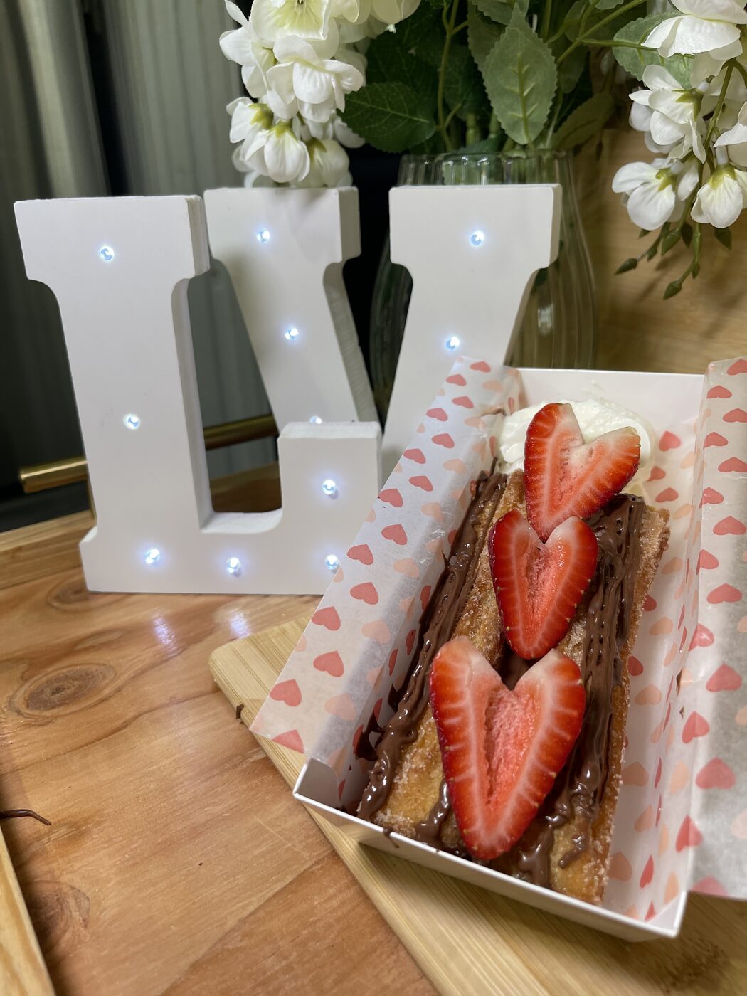 Churro with Nutella, whipped cream, and heart-cut strawberries